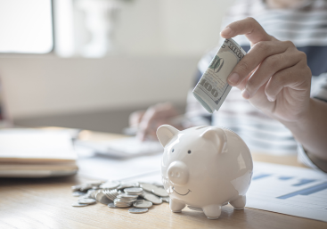 Imagine of someone putting money in a piggy bank suggesting clicking on this field will direct to topics related to savings